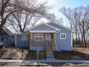 Blue and white Habitat house with covered porch