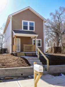 Brown two-story Habitat home with covered porch