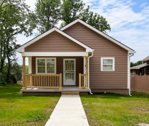 Brown Habitat home with white trim and covered porch